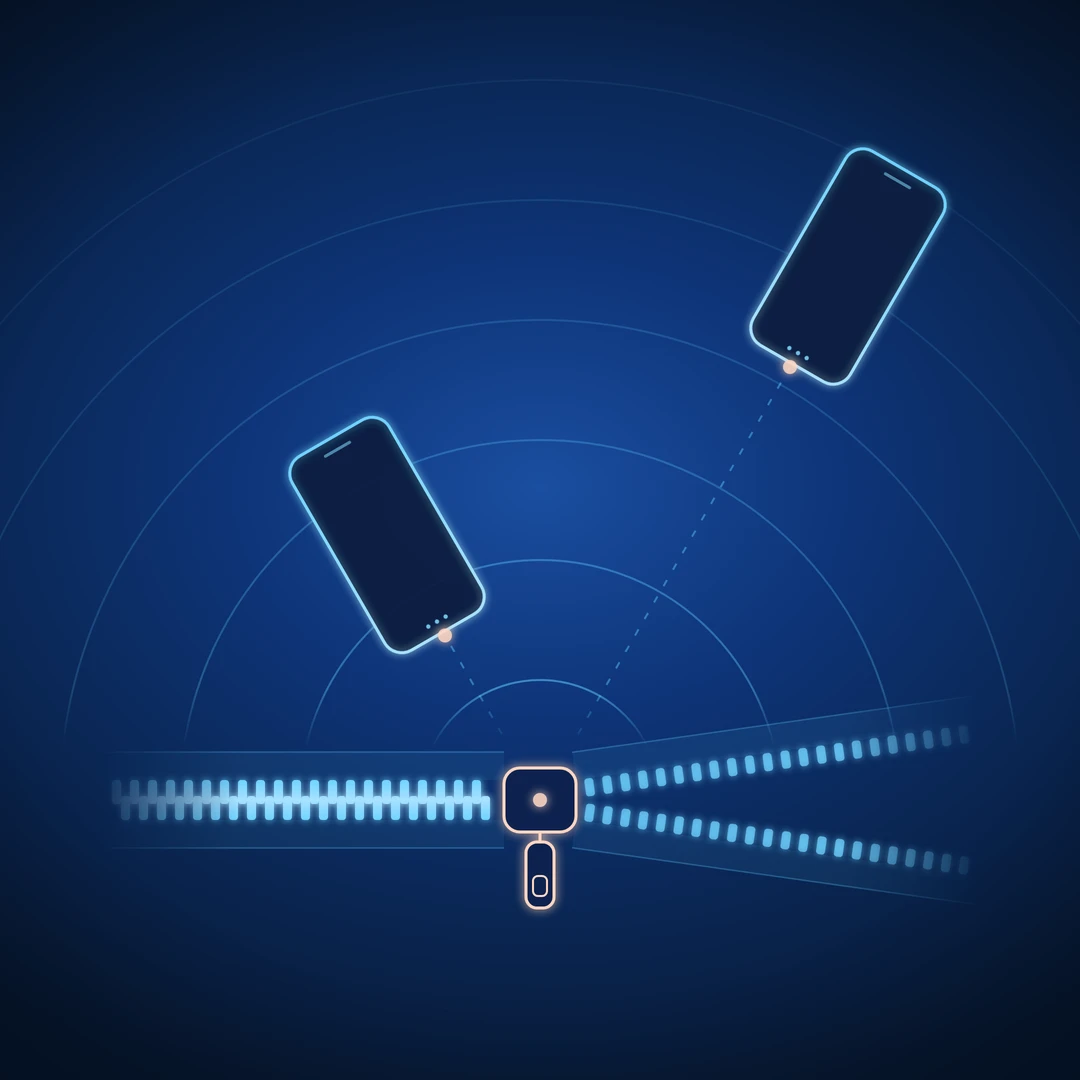 A zipper with its pull tab marked, and two phones pointed at it from two distances — one close, inside the inner rings of sound, and one farther out where the rings have spread